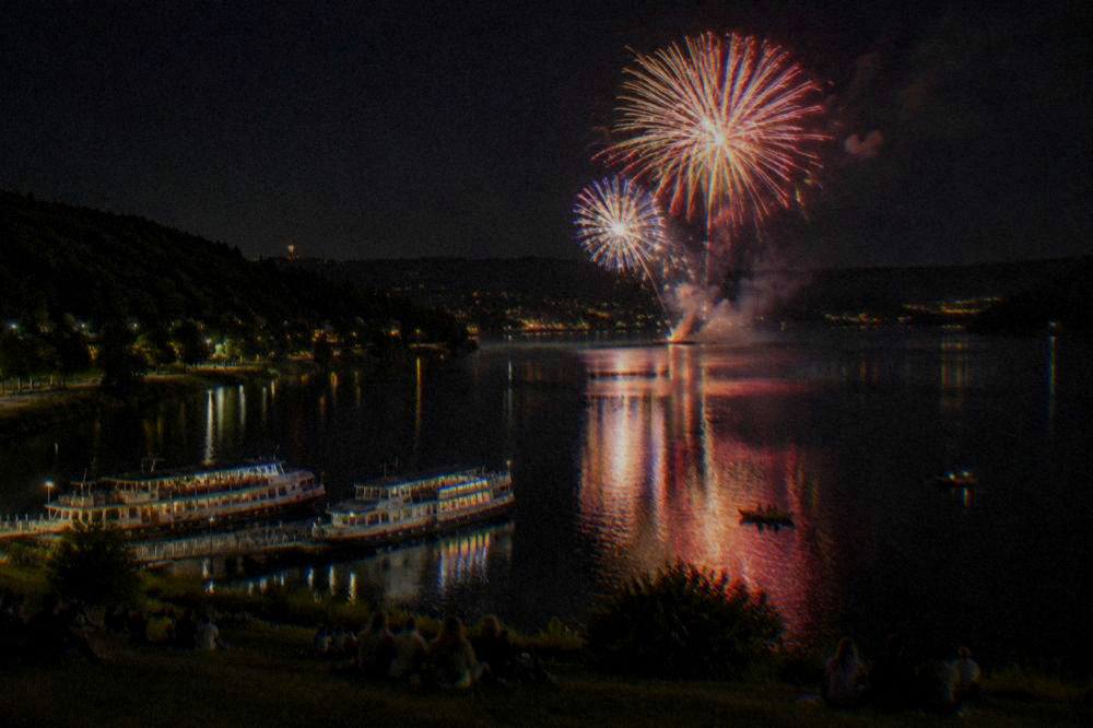 Fireworks bursting above the dark water of the Brno Reservoir at night