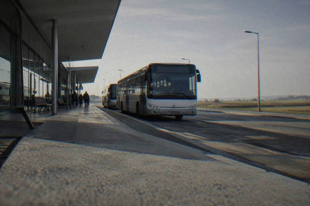 Bus parked outside an airport terminal at a sheltered stop