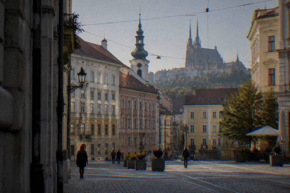 Colourful historic buildings and a church tower around a square in Brno's old town