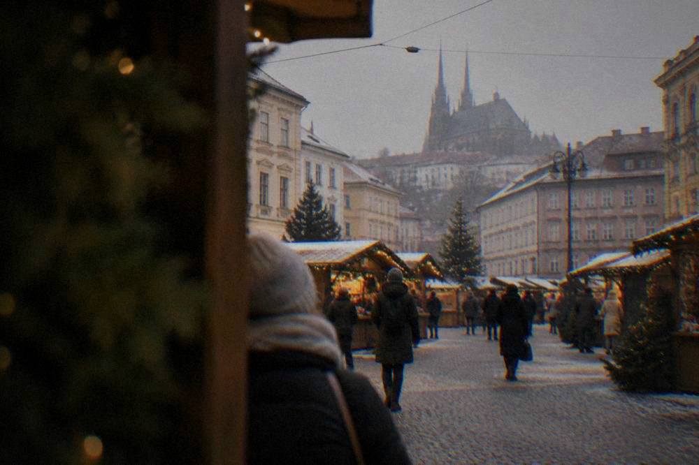 Christmas market stalls with lights in front of historic buildings on a Brno square