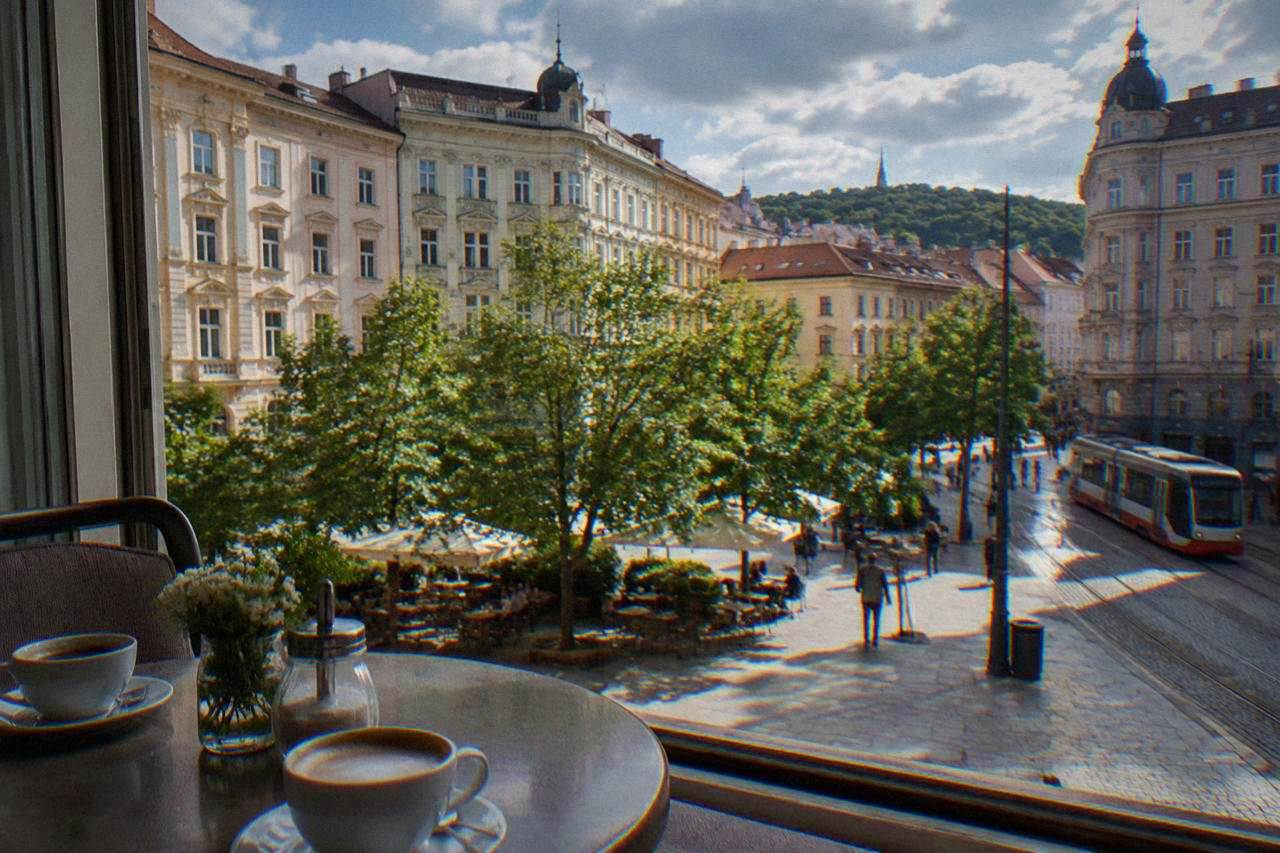 Cups of coffee on a café table beside a window in a historic city square
