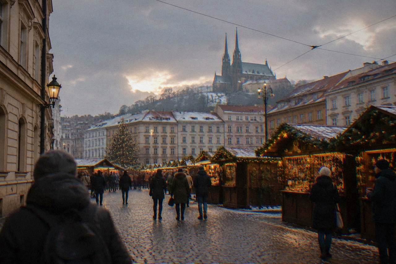 Christmas market stalls with glowing lights in a historic square in Brno at dusk