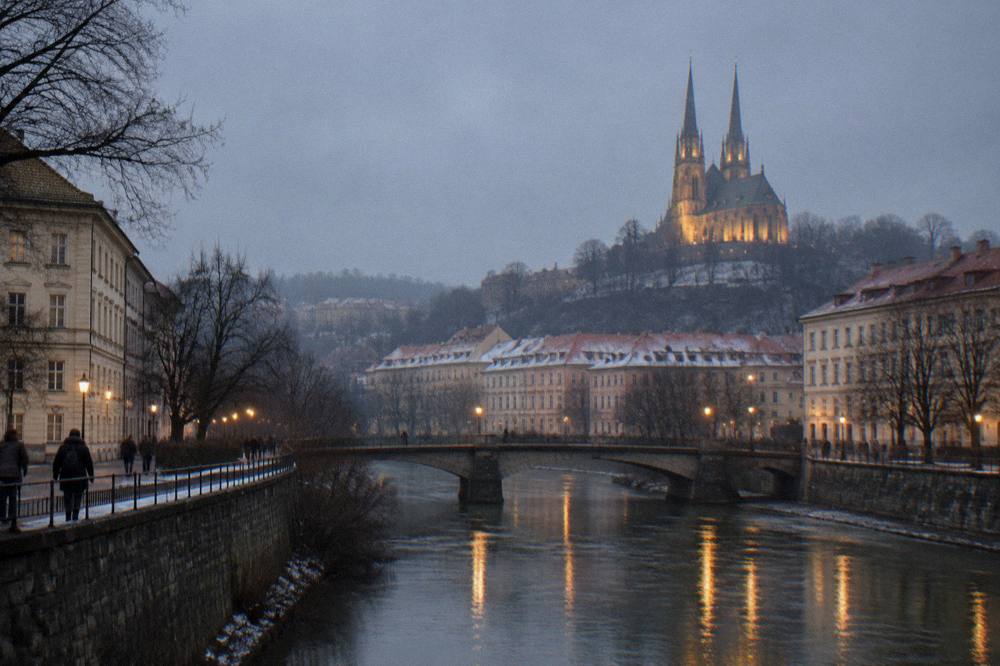 The illuminated twin spires of the Cathedral of Sts Peter and Paul above Brno at dusk in winter