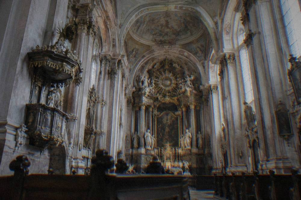 Baroque interior of a church in Brno with columns and an ornate altar