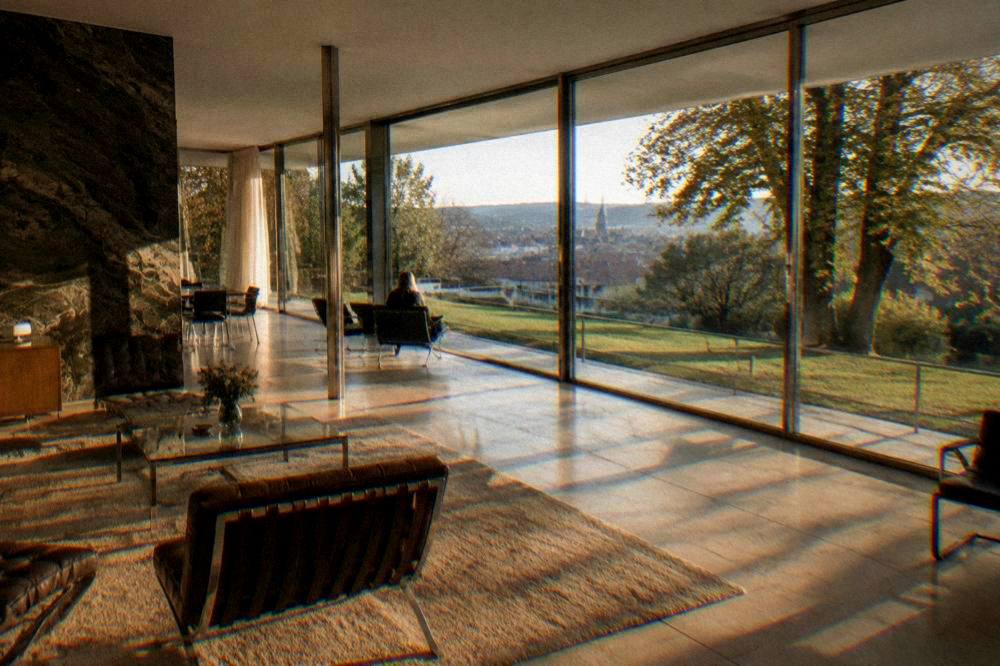 The glass walled main living space of Villa Tugendhat in Brno with its onyx wall and garden view