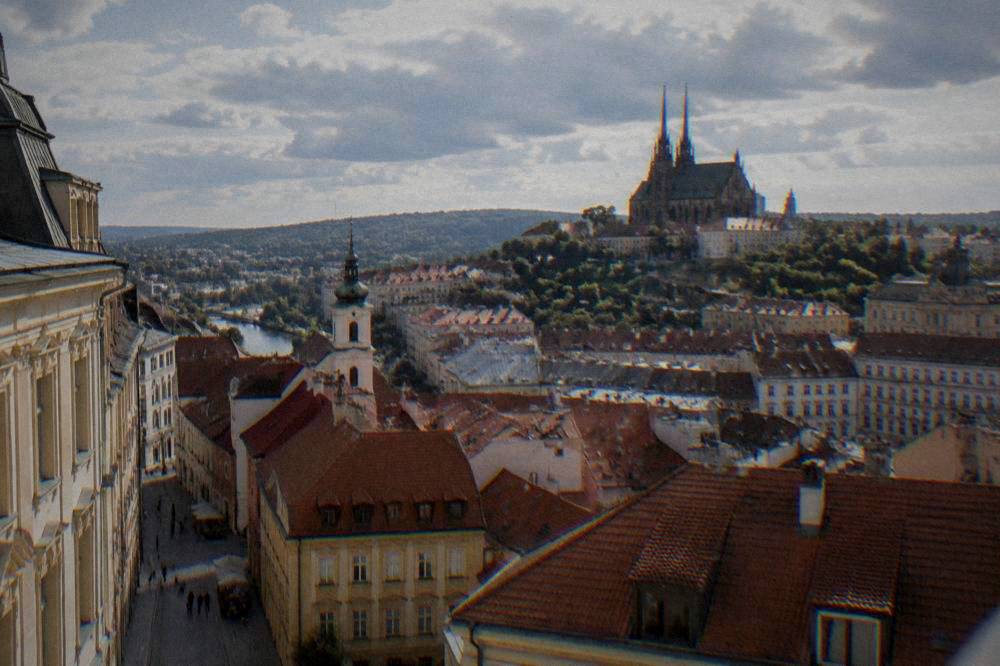 View over red rooftops of Brno old town toward church towers from a high vantage point