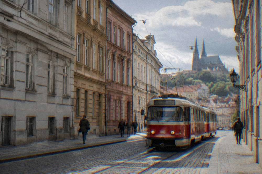 A tram moving along a street in central Brno past historic buildings