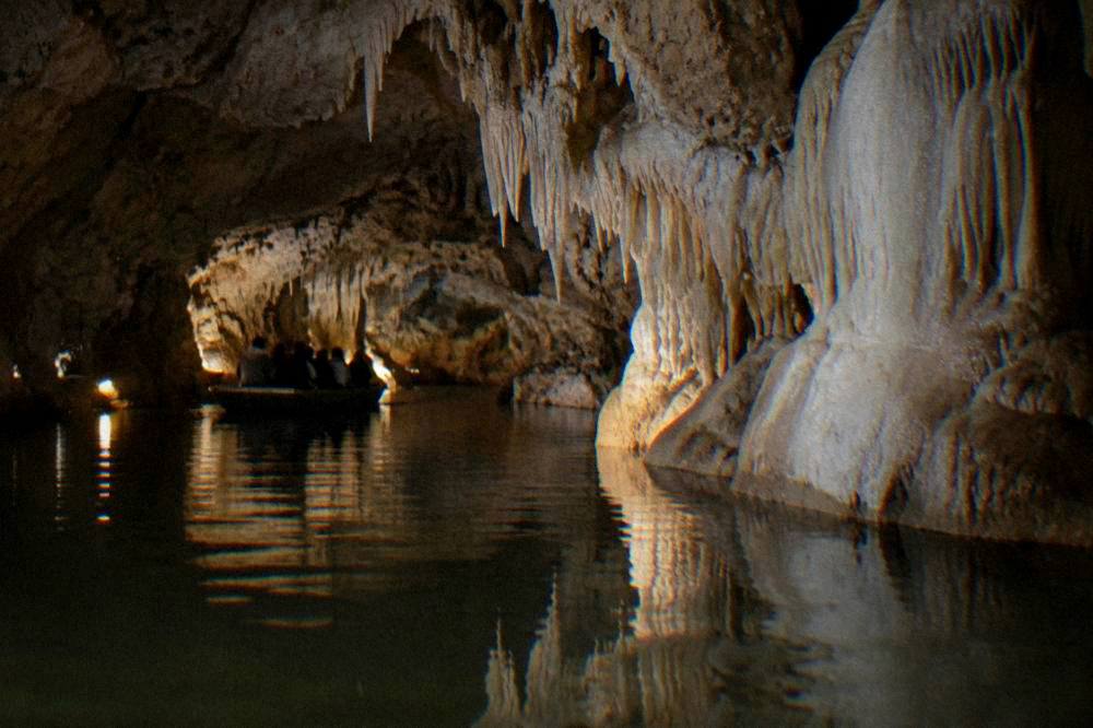 The lake of the Punkva Caves tour reflecting the rock walls inside the Moravian Karst