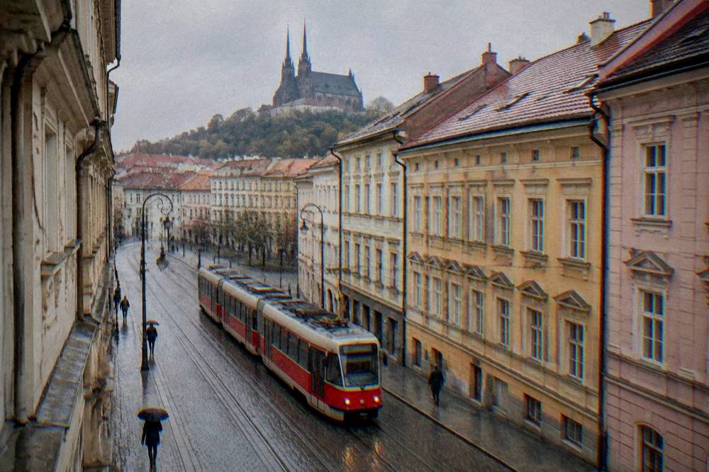 Red tram passing historic buildings on a Brno street