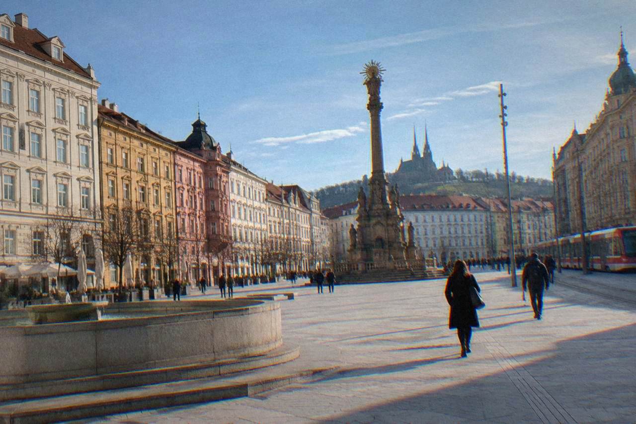 Freedom Square in Brno with the plague column and coloured baroque houses under a blue sky