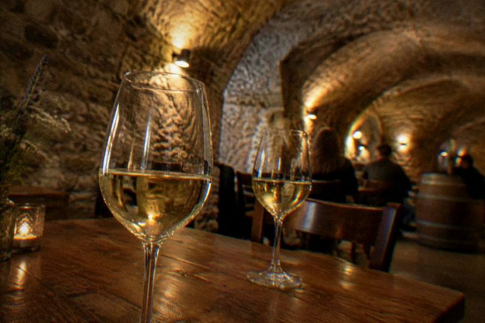Glasses of Moravian white wine on a wooden table in a vaulted cellar