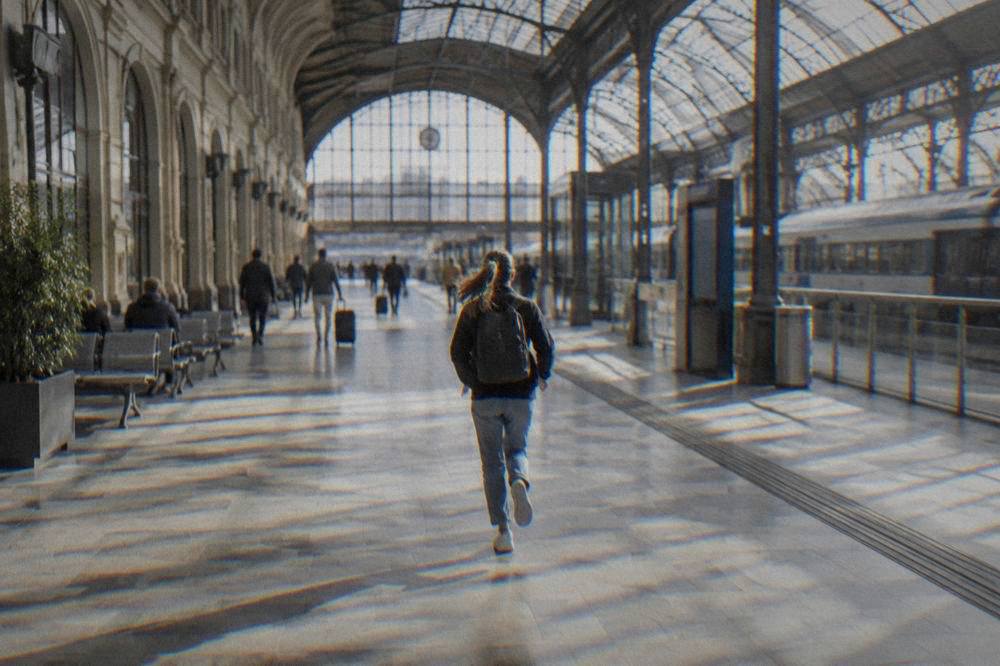 The station hall of Brno main station with departure boards and travellers reading timetables