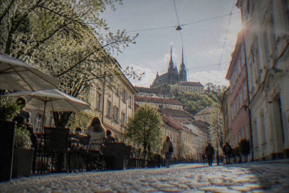 Cobblestone street in central Brno on a bright spring day with cafe tables outdoors