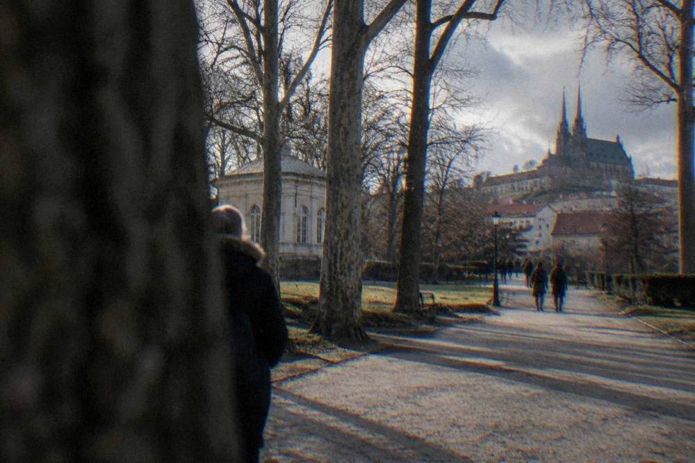 Visitors walking up toward the Cathedral of Sts Peter and Paul on Petrov Hill under grey clouds
