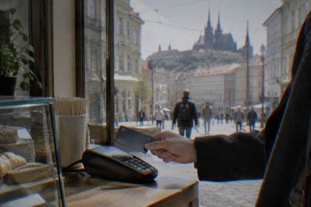 A contactless card payment terminal at a shop counter in Brno