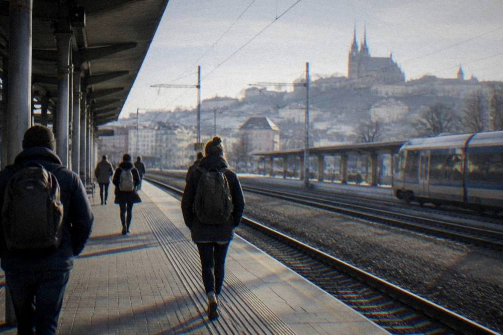 A train station platform in Brno with travellers carrying backpacks