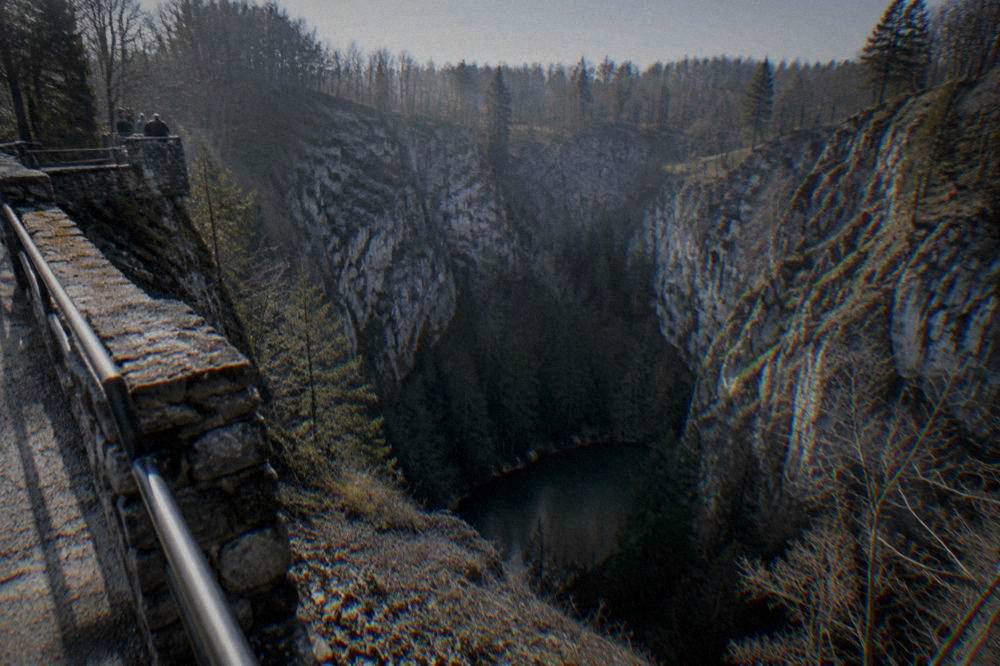 A deep forested limestone gorge with viewing platforms at Macocha Abyss