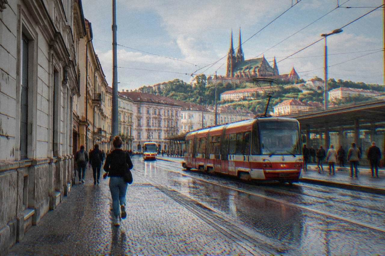 Trams and pedestrians in front of Brno main train station on a bright day