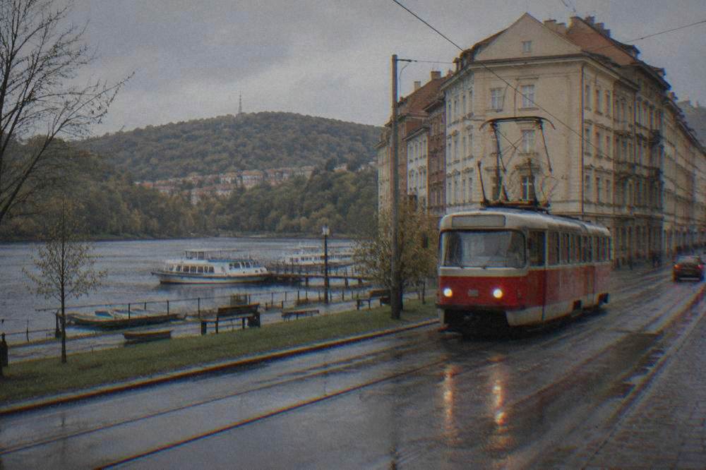 A red tram moving along a street lined with older apartment buildings