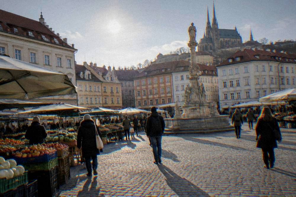 Visitors walking across the Cabbage Market square in Brno on a sunny afternoon
