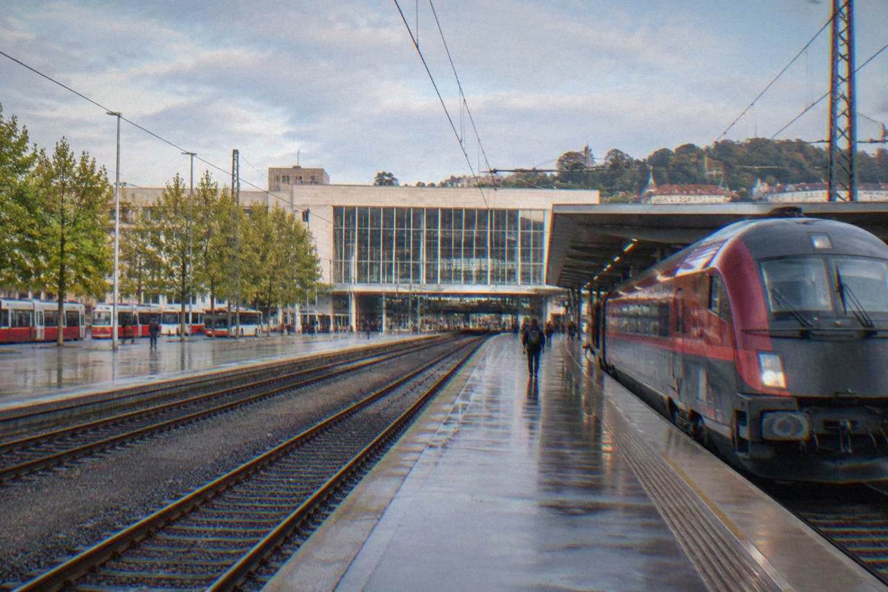 A red and grey express train waiting at a platform in a Czech railway station