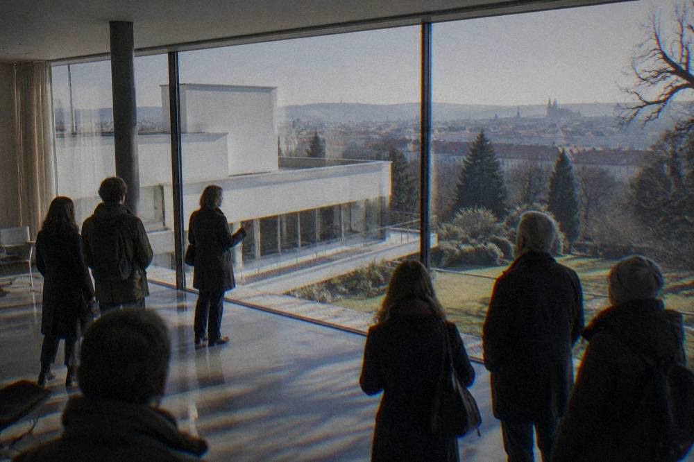 Tour group standing in a bright modernist interior with a polished floor and large windows