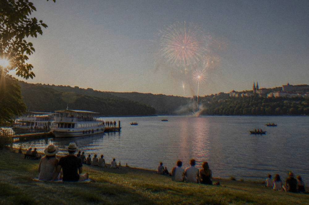 Fireworks bursting over the dark water of the Brno Reservoir during a summer festival