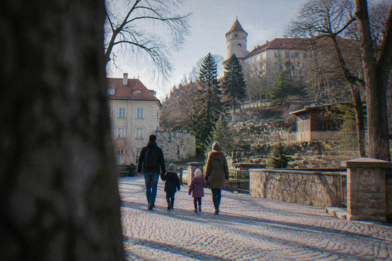 Family with two children walking across a historic square with a castle hill in the background