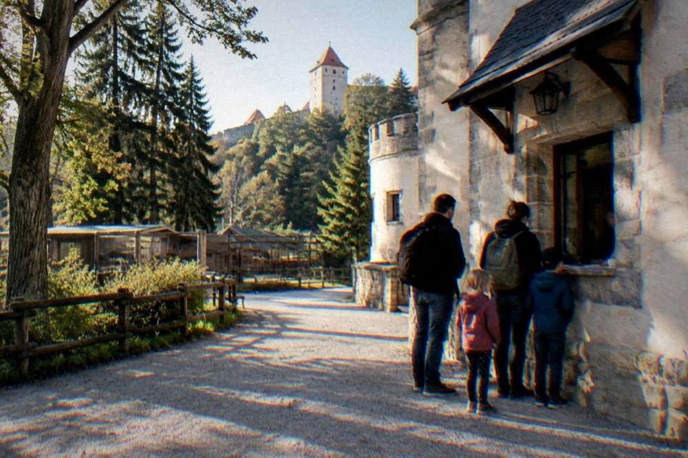 Parents and children buying tickets at a castle ticket counter window
