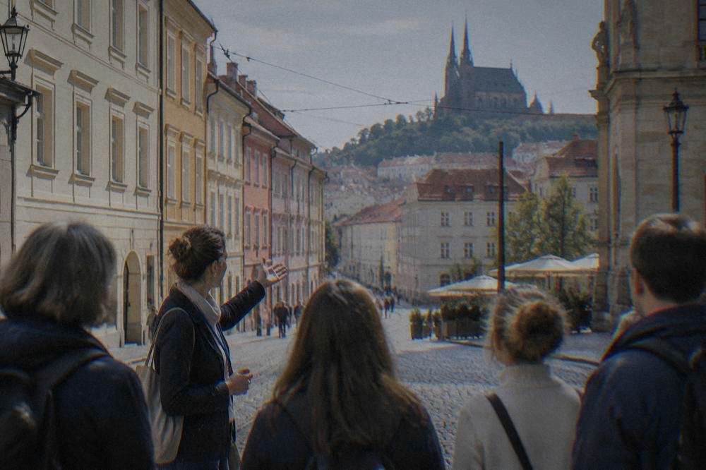 Tour guide speaking to a small group of visitors on a cobbled street in central Brno