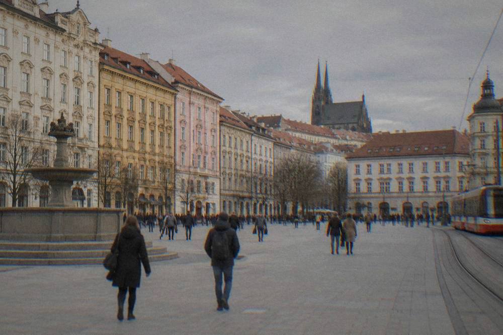 Visitors walking past colourful baroque buildings on Freedom Square in Brno