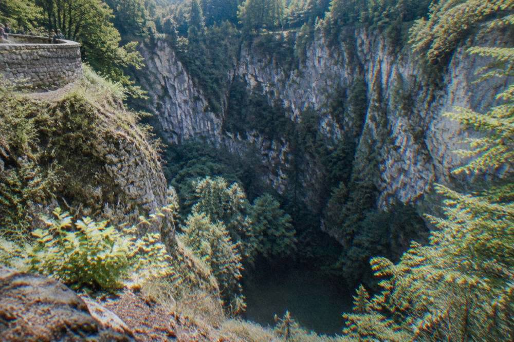 View from the upper rim of the Macocha Abyss looking down into a forested gorge