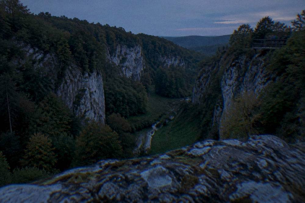 Steep forested cliffs of a limestone gorge with viewing platforms at the top